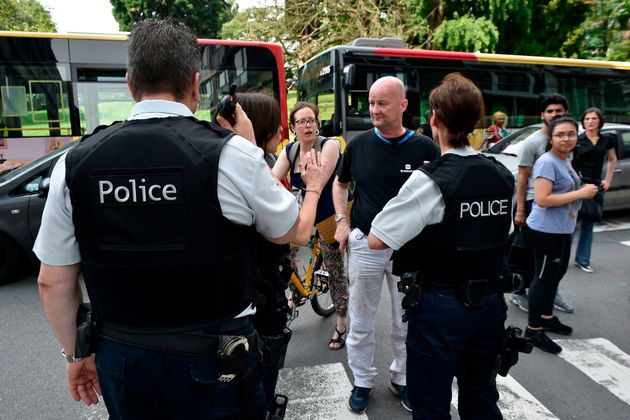 A police officer speaks with parents of children at a nearby high school in the eastern Belgian city of Liege.