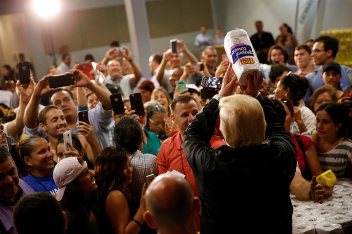 U.S. President Donald Trump bizarrely tosses rolls of paper towels to people at a hurricane relief distribution center at Calvary Chapel in San Juan, Puerto Rico, U.S. Oct. 3, 2017