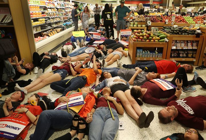 Protesters stage a "die in" protest at a Publix supermarket in Coral Springs, Florida, after the grocery store chain gave political contributions to an NRA-backed gubernatorial candidate.