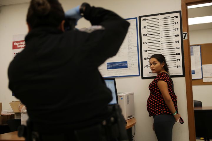 A pregnant woman who is seeking asylum has her picture taken by a U.S. Customs and Border patrol officer at a pedestrian port of entry from Mexico to the United States in McAllen, Texas, on May 10, 2017.