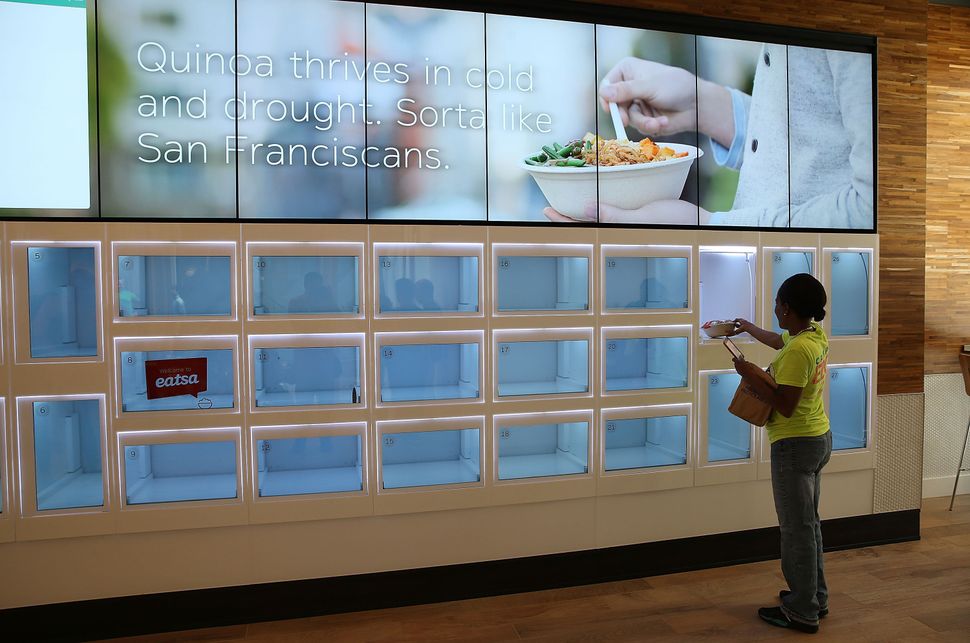 A customer picks up her food from a cubby at Eatsa, a largely automated restaurant in San Francisco.