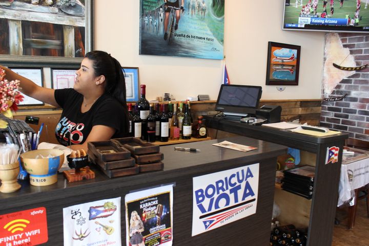 Mariner Ostolaza, 28, rings up a bill at Isla Del Encanto, the Puerto Rican restaurant in the Kendall section of Miami-Dade County where she works. 