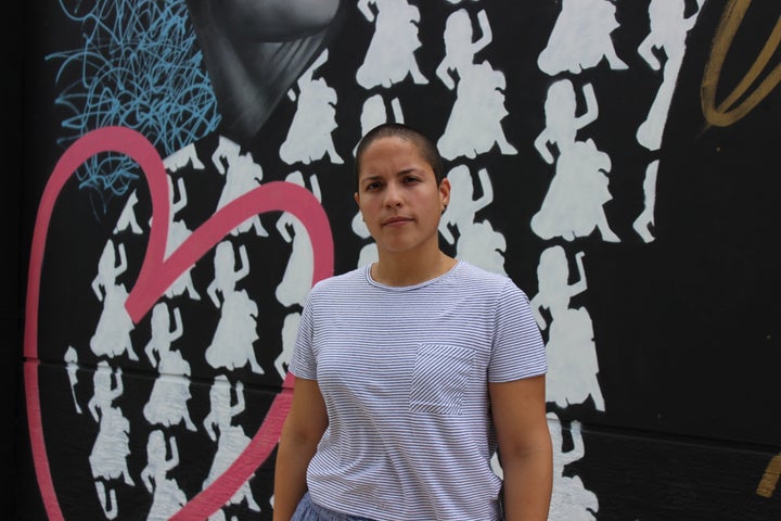 Andrea Ruiz-Sorrentini, a University of Miami researcher studying Puerto Ricans evacuees in Miami, stands before a mural at the community center in Roberto Clemente Park. 