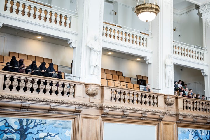Women in niqabs observe the Danish Parliament as it bans face veils in public in a vote Thursday at Christiansborg Palace in