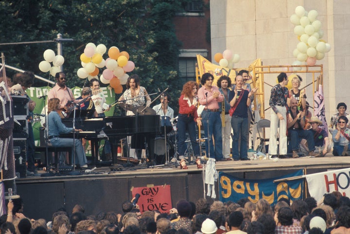 Barry Manilow (seated at piano) and Bette Midler (at center, in red) at a Gay Liberation rally at Washington Square Park on June 24, 1973, in Greenwich Village, New York City.