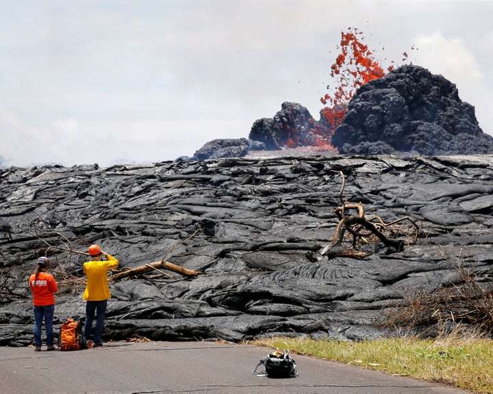 Officials from the U.S. Geological Survey Hawaiian Volcano Observatory watch lava erupting from a fissure in the Leilani Estates near Pahoa, Hawaii, on May 24.