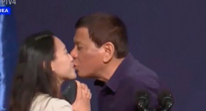 Philippine President Rodrigo Duterte plants a kiss on a Filipino woman's lips 