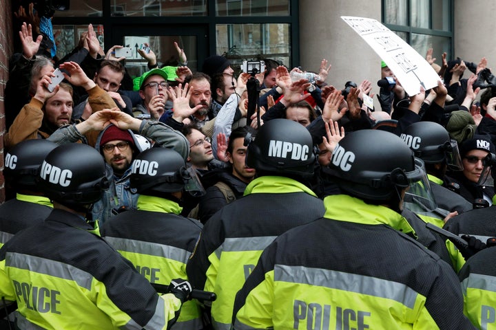 Several of the protesters who took to the streets of Washington on President Donald Trump's inauguration day raise their hands as police surround them.