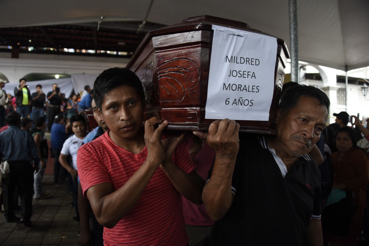Two men carry the coffin of a little girl who died following the eruption of the Fuego volcano.