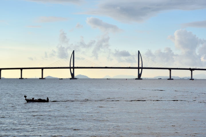 A fishing boat in front of Hong Kong - Zhuhai - Macao bridge in Zhuhai city, Guangdong Province, South Coast of China.