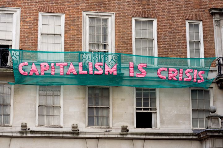 <em>Protestors hang anti-capitalism slogans on buildings on Clarges Street in London during the demonstrations against public sector funding cuts in March 2011</em>