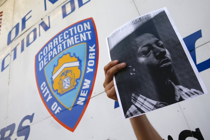 A demonstrator holds a photo of Kalief Browder during a candlelight vigil outside the entrance to the Rikers Island correctional facility in Queens, June 11, 2015.