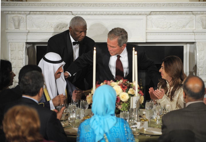 President George W. Bush takes his seat next to Kuwait's former Prime Minister Nasser al-Mohammed al-Ahmed al-Jaber al-Sabah (left) during an iftar dinner with ambassadors and Muslim leaders on Sept. 17, 2008.