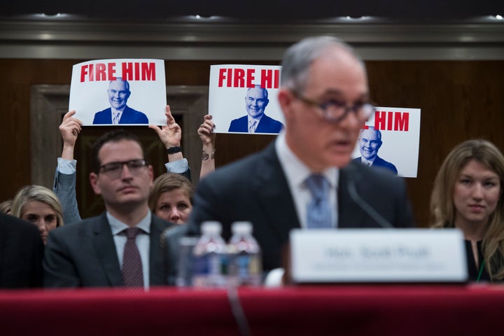 Protesters hold signs as Pruitt testifies during a Senate hearing on the proposed fiscal year 2019 budget for the EPA in May 2018.