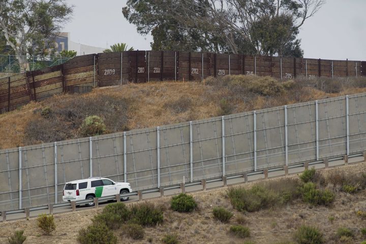 A Border Patrol car drives past the old border wall just east of where construction is set to begin on new fencing in San Ysidro, California.