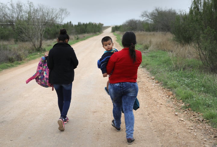 Central American immigrants walk after crossing the U.S.-Mexico border to turn themselves in to Border Patrol agents in Febru