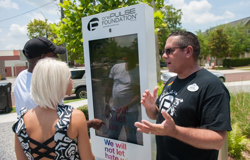 Miguel Dionisi, a volunteer from Disney, explains how the new digital guestbook kiosk works to visitors at the Pulse mem
