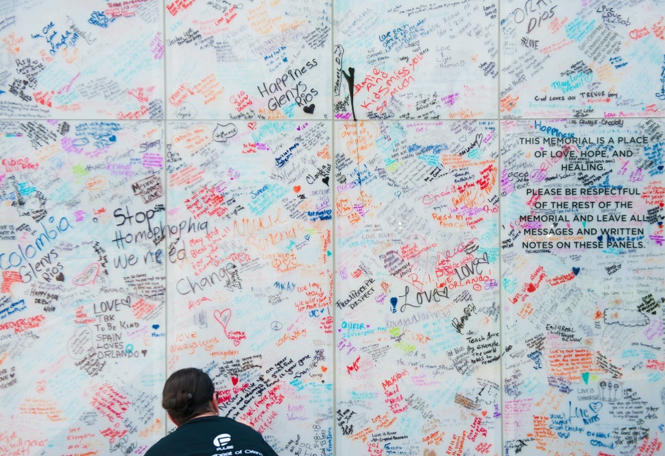Angie Sola, a volunteer with Disney, leaves a message on the Pulse sign at the memorial.