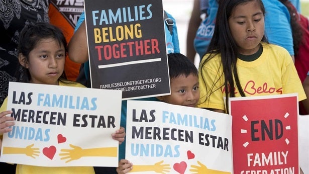 Children in front of the Miramar, Florida, U.S. Immigration and Customs Enforcement offices this month hold up signs in protest of a new policy of separating migrant children from their families. Officials can now investigate and possibly arrest and deport people who agree to host migrant children.