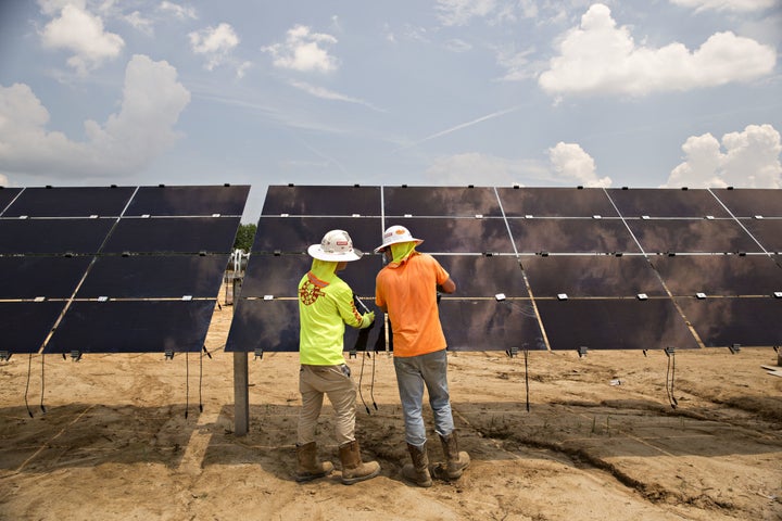 Workers torque mounting brackets on a row of solar panels during construction of a Silicon Ranch Corp. solar generating facility in Milligan, Tennessee, on May 24.