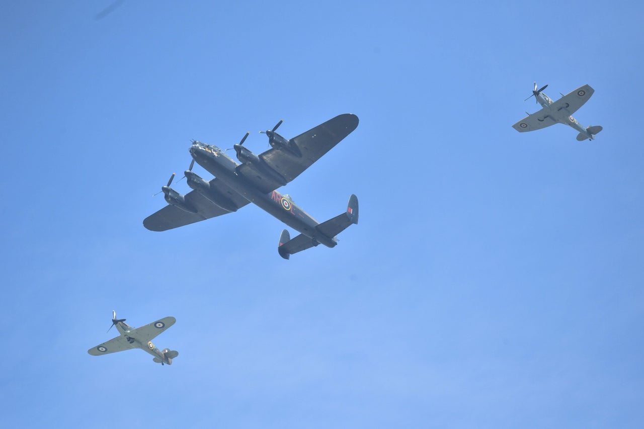 A Hurricane (left) and a Spitfire escort a Lancaster during a flypast over Buckingham Palace.