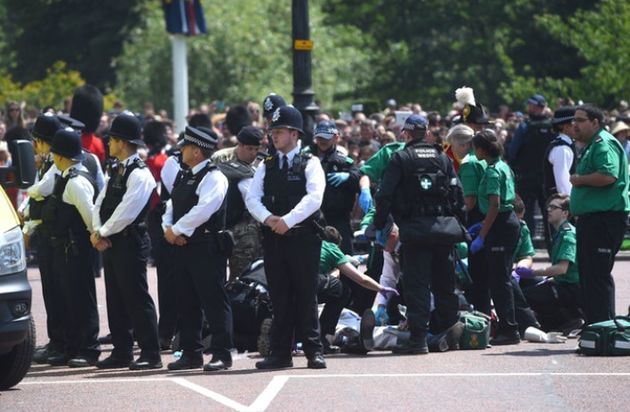 Police officers stand guard as Lord Guthrie is attended to by paramedics