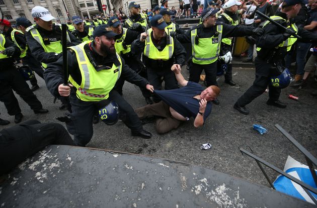 Riot police deal with a protester at the Free Tommy rally in London