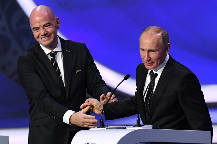 FIFA president Gianni Infantino smiles with Russian President Vladimir Putin while delivering speeches during the 2018 FIFA World Cup football tournament final draw at the State Kremlin Palace in Moscow on Dec. 1, 2017.