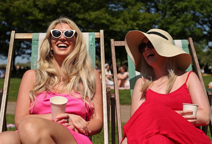 Grainne Gallanagh (left) and Ruth Chalke sunbathing in the hot weather on a Bank Holiday, in Hyde Park, London