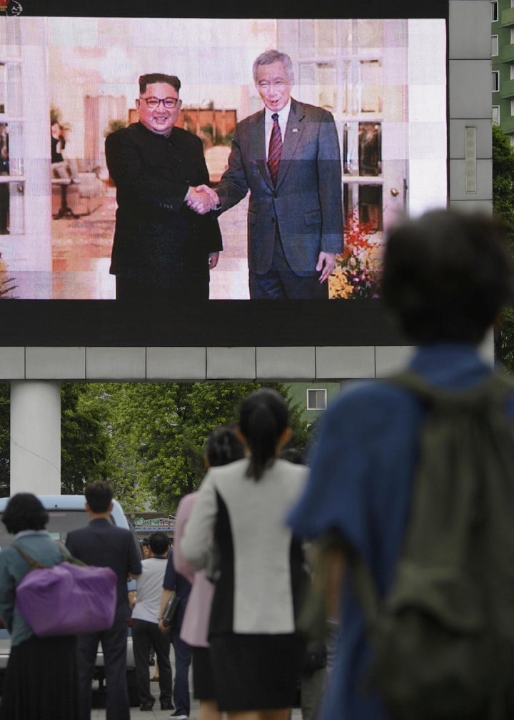 North Koreans watch a news report on North Korean leader Kim Jong Un's visit to Singapore in Pyongyang, North Korea, on June