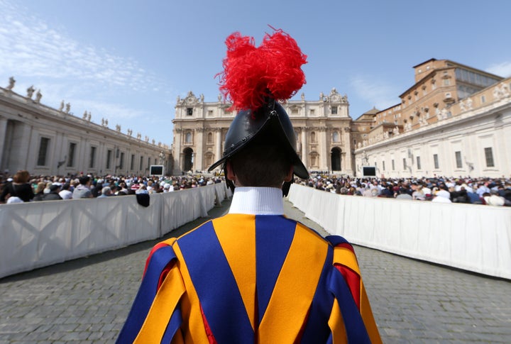 A Swiss guard stands in front of Saint Peter's Basilica during a Holy Mass at the Vatican on April 8, 2018.