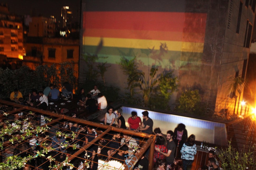 A rooftop party with a rainbow flag projected on the neighboring building during Beirut Pride 2017.