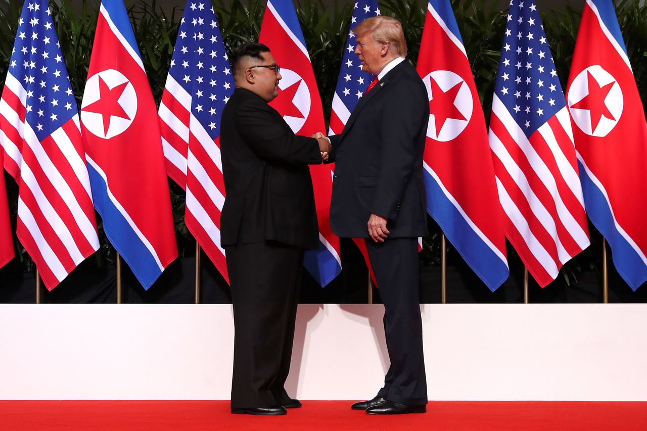 Meeting in the middle: US President Donald Trump and North Korea's leader Kim Jong Un symbolically shake hands on stage at the Capella Hotel on Singapore's resort island of Sentosa 