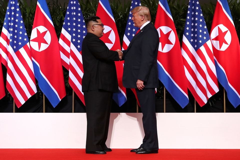 Meeting in the middle: US President Donald Trump and North Korea's leader Kim Jong Un symbolically shake hands on stage at the Capella Hotel on Singapore's resort island of Sentosa 