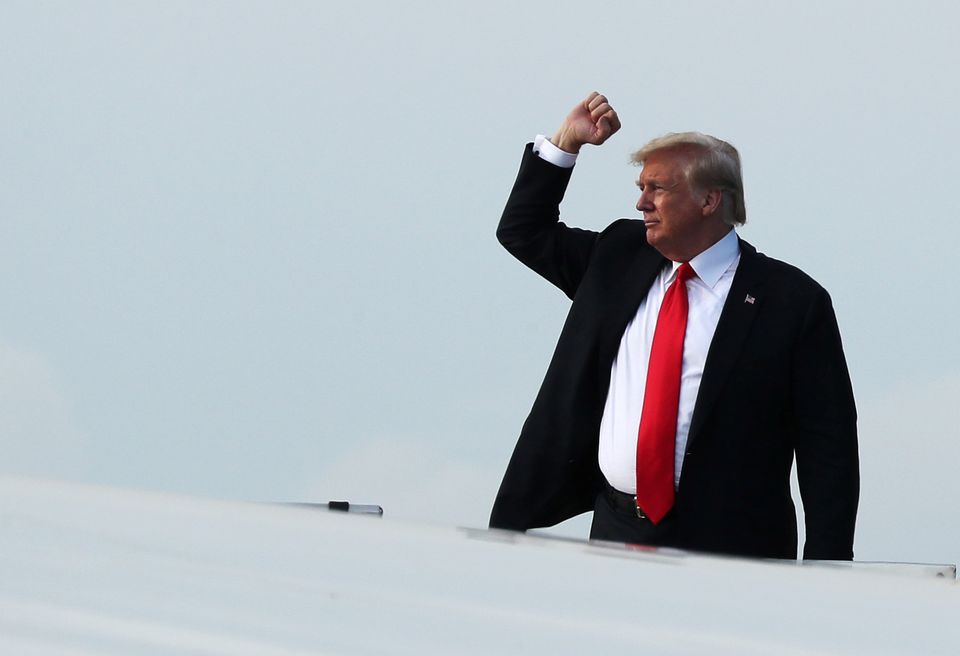 And he's off! Trump brandishes his fist before boarding Air Force One and leaving Singapore 