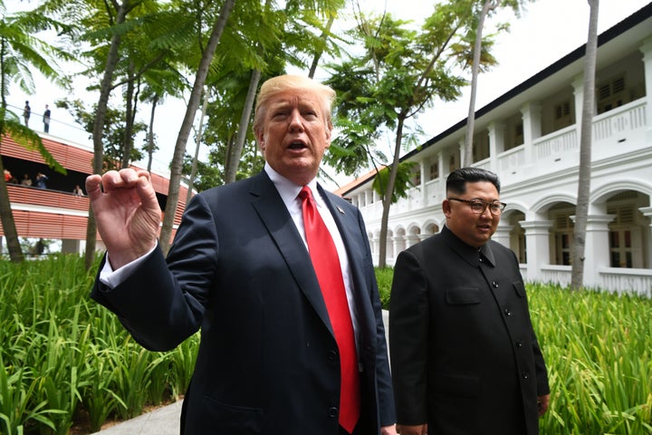 President Donald Trump speaks to the media as he walks with North Korean leader Kim Jong Un during a break in talks at their summit in Singapore.