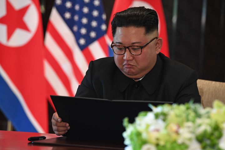 Kim looks at his document at a signing ceremony with Trump. The brief, vague joint statement included a clause stating "the DPRK commits to work toward complete denuclearization of the Korean Peninsula."