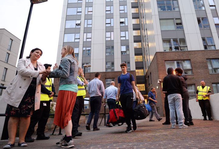 Residents leave the Taplow tower block on the Chalcots Estate in Camden, London, as the building is evacuated in the wake of the Grenfell Tower fire.