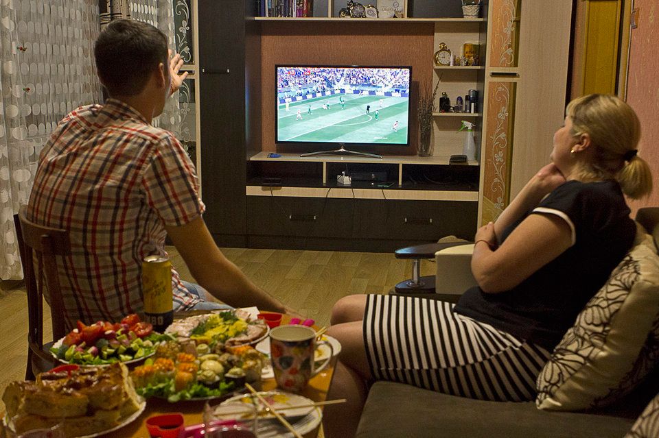 Anatolii and Julia in front of the TV watching the game.