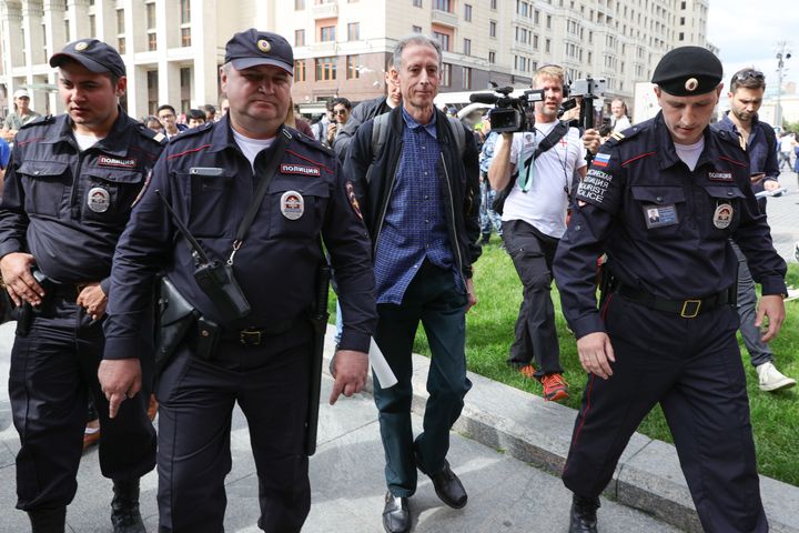 Gay rights campaigner Peter Tatchell (centre) is led away by Russian authorities in Moscow after staging a one-man protest near Red Square.