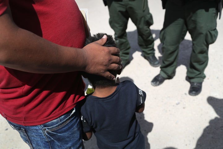 U.S. Border Patrol agents take a father and son from Honduras into custody near the U.S.-Mexico border on June 12 near Missio