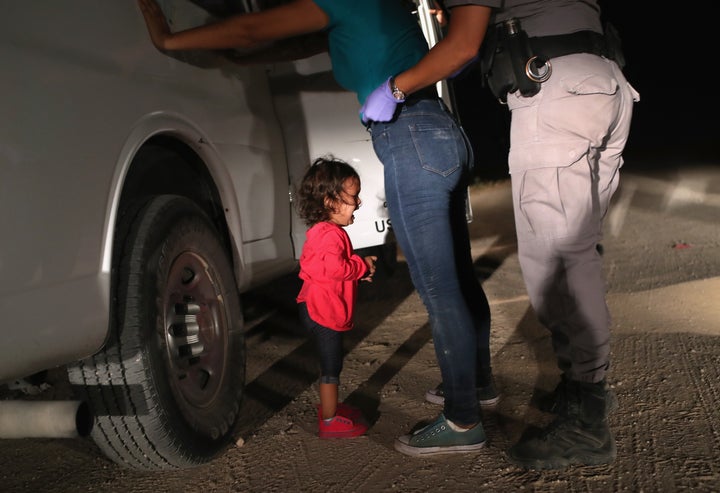 A 2-year-old Honduran asylum seeker cries as her mother is searched and detained Tuesday near the border in McAllen, Texas.