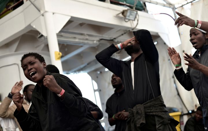 Migrants sing on the deck of MV Aquarius, a search and rescue ship run in partnership between SOS Mediterranee and Medecins Sans Frontieres on their way to Spain on Saturday.