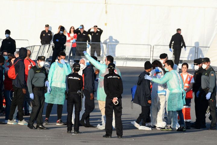 Red Cross members, Spanish Guardia Civil guards and Spanish policemen welcome migrants from the Italian coast guard boat the Dattilo at the port of Valencia on June 17.