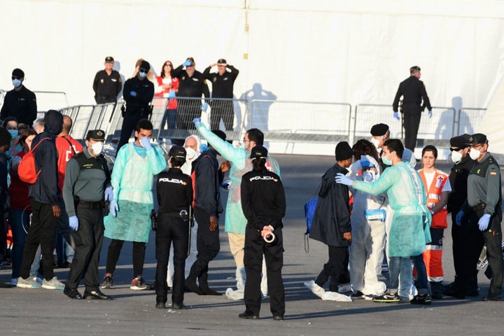 <strong>Red Cross members, Spanish Guardia Civil guards and Spanish policemen welcome migrants from the Italian coast guard boat the Dattilo at the port of Valencia on June 17.</strong>