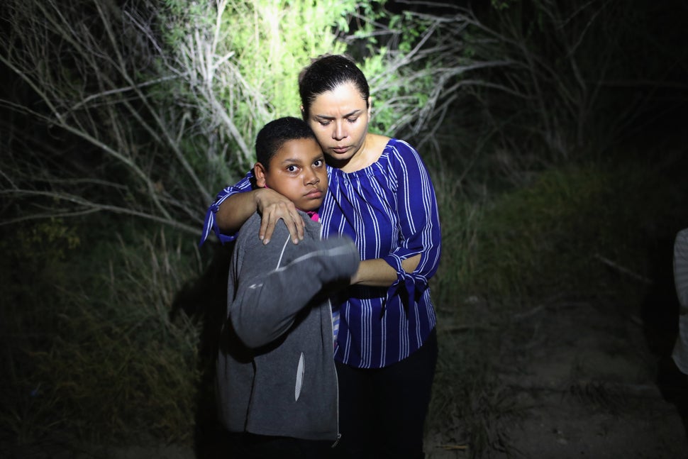 A U.S. Border Patrol spotlight shines on a terrified mother and son from Honduras as they are found in the dark near the U.S.