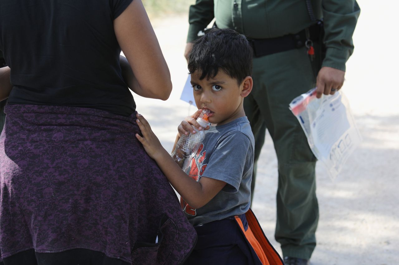 Central American asylum seekers wait as they are taken into custody on June 12, 2018.