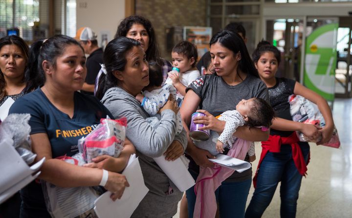 Immigrants wait to head to a nearby Catholic Charities relief center after being dropped off at a bus station shortly after release from detention through "catch and release" immigration policy on June 17 in McAllen, Texas.