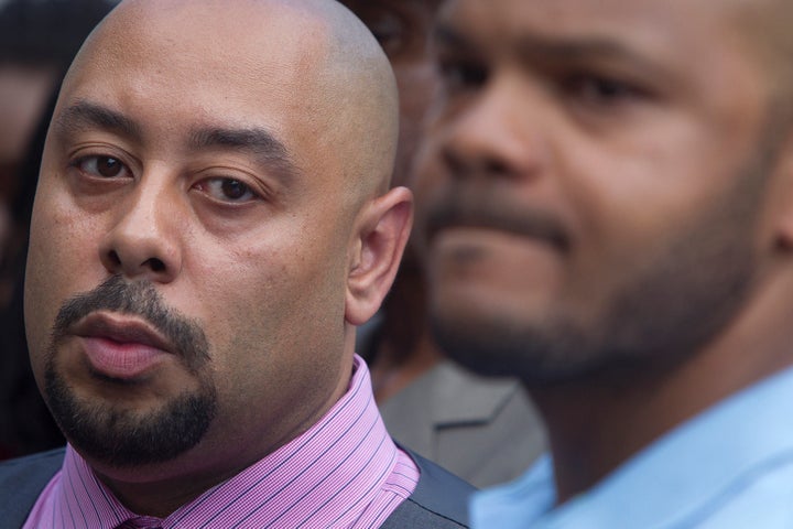 Raymond Santana (left) listens during a 2014 news conference announcing the Central Park Five's settlement with the city of New York.