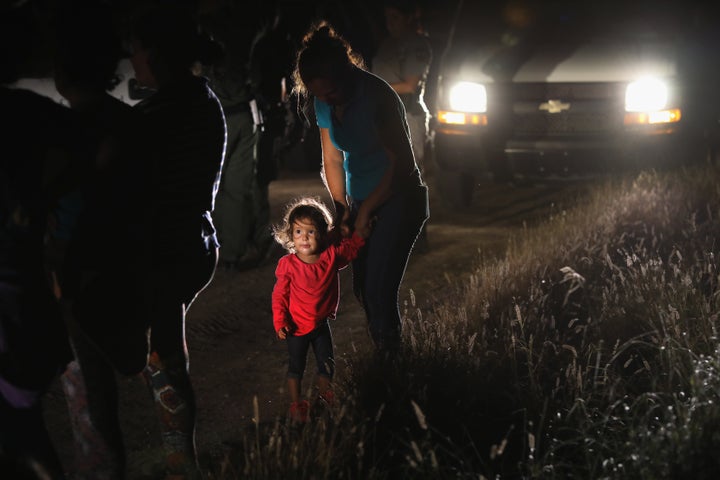 A 2-year-old Honduran stands with her mother after being detained by U.S. Border Patrol agents near the U.S.-Mexico border on June 12.